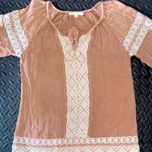 Baggy, casual, peachy-pink colored top, cream colored hemming and styled strings